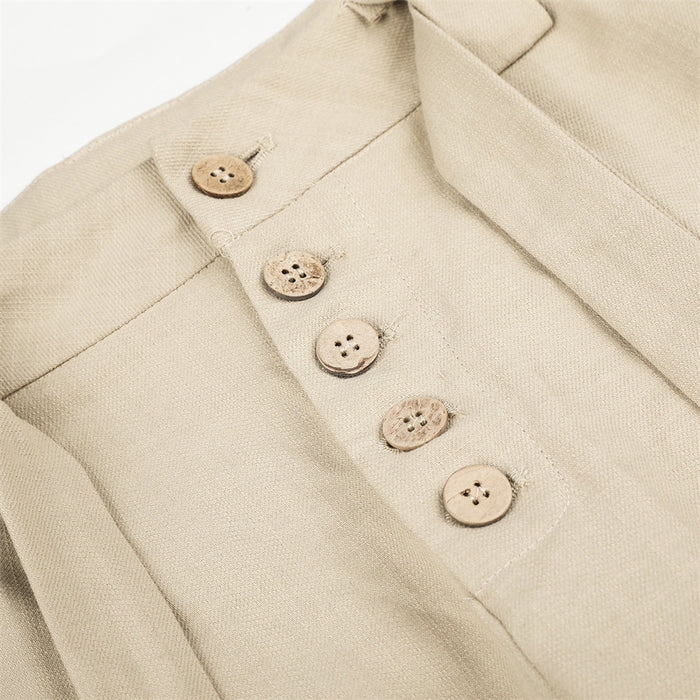 Close-up of beige button fly with five buttons on pleated wide-leg trousers