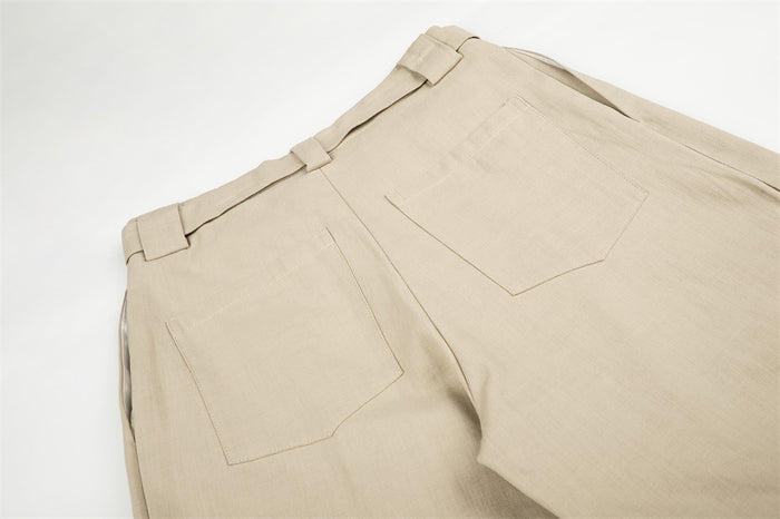 Back waist view of beige wide-leg trousers with belt loops and patch pockets