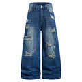 Men's wide-leg baggy ripped jeans in medium blue washed denim with heavy distressing and frayed tear details, front and back