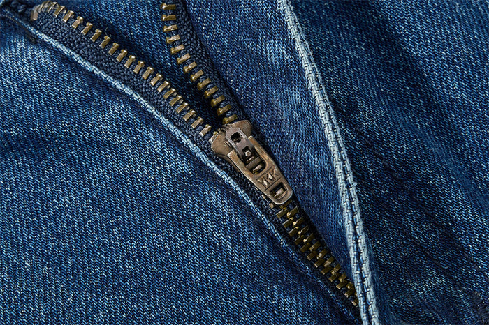 Close-up of metal zipper on blue denim jeans