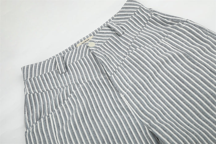 Close-up of waistband and front pocket area on gray striped wide-leg pants